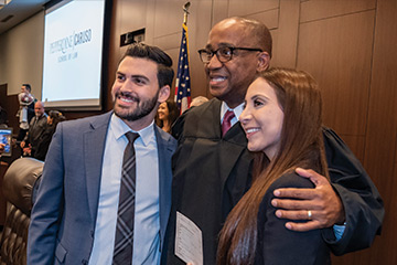 Judge Andre Birotte pictured standing between a male and female student